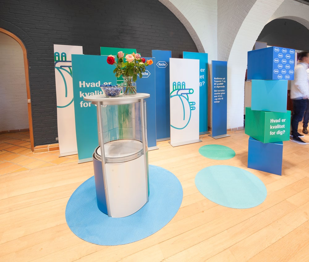 Roche messestand med brandgrafik og produktområde